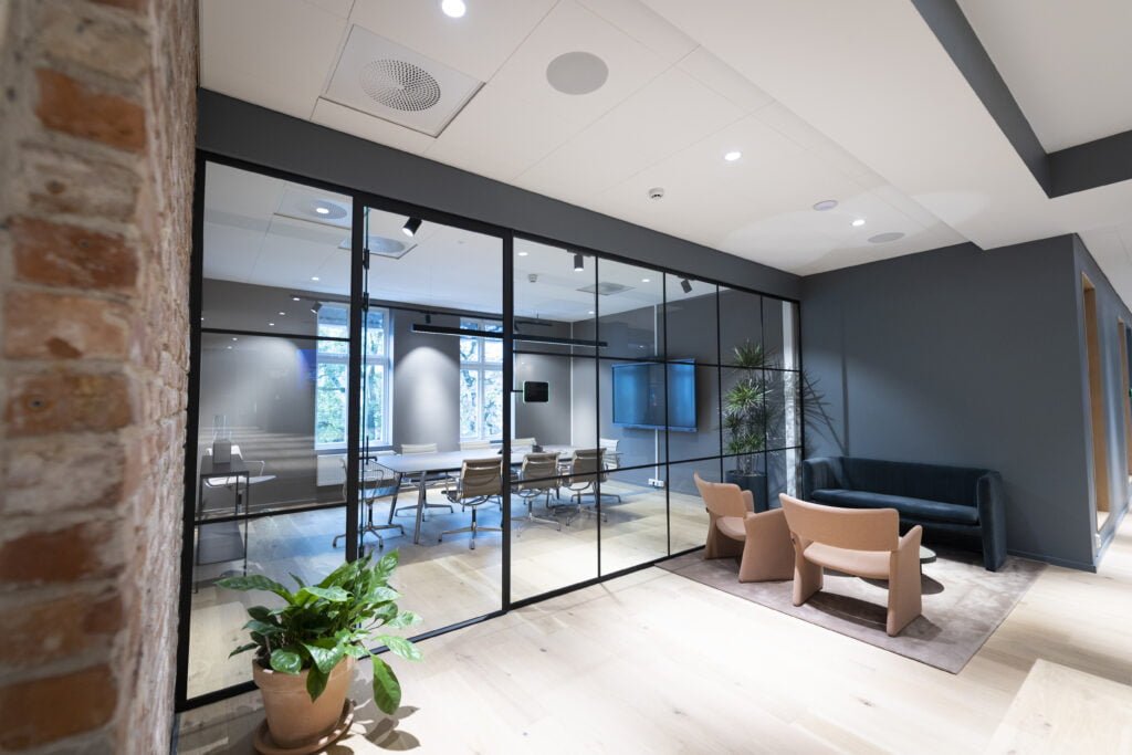 Stor glassvegg foran et møterom, installert av System 1.